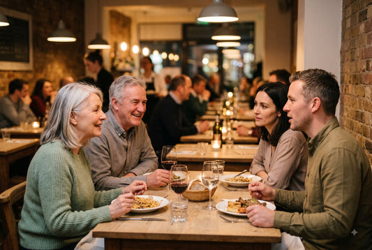 Mehrere Personen an einem Tisch in einem vollen Restaurant im Gespräch