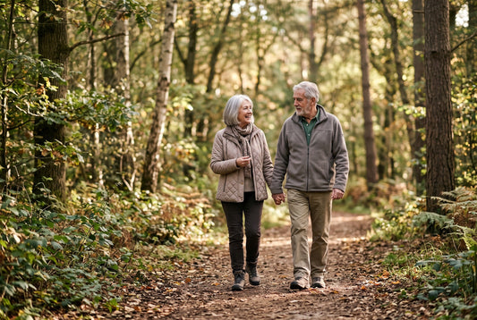 Älteres Paar geht auf einem Waldweg nebeneinander